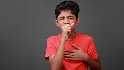 teenager covering a cough
