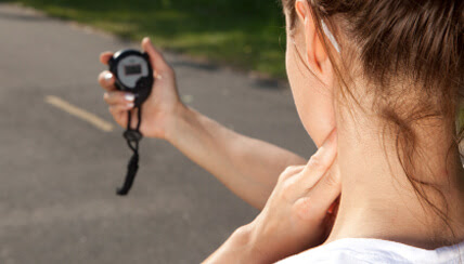 Female jogger reviewing stop watch to measure target heart rate