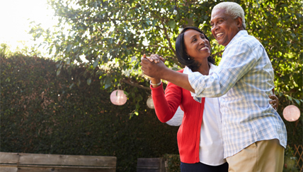 Two seniors dancing in the park