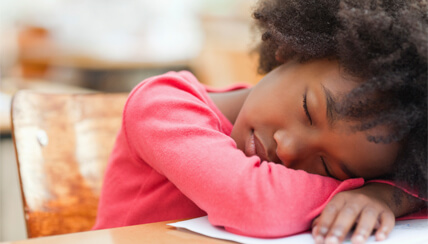 child asleep at her desk