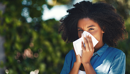 Woman holding tissue to face